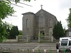 The Catholic parish church. An inscribed stone high up on the gable reads "THIS TEMPLE was erected to the honour and glory of GOD By the Revd George Canavan P.P. in the year of our Lord 1836"