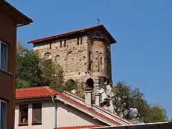 Southeast view of a narrow medieval church topping a cliff