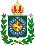 Coat of arms consisting of a shield with a green field with a golden armillary sphere superimposed on the red and white Cross of the Order of Christ, surrounded by a blue band with 20 silver stars; the bearers are two arms of a wreath, with a coffee branch on the left and a flowering tobacco branch on the right; and above the shield is an arched golden and jeweled crown.