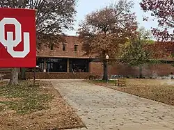 Front of Andrew M. Coats Hall with an OU banner on a pole to the left