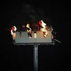 A burning house shown over a black background