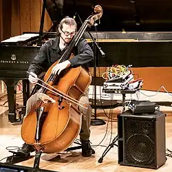 Experimental double-bassist Gahlord Dewald performing with modular synthesizer