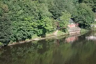 A picture of Durham School Boat Club's boat house in summer, taken from Prebends Bridge