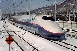 An 8-car Nagano Shinkansen E2 series set J6 arriving at Karuizawa Station on a Tokyo-bound Asama service in February 1998