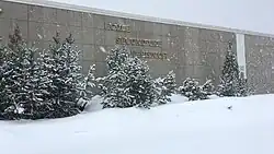 A one-storey stone building with École Secondaire Népisiguit written on the front during a snowstorm.