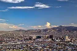 Buildings and mountains in a large city during the afternoon