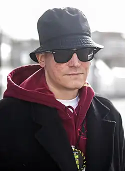 Piskor wearing a hat, hoodie, and glasses