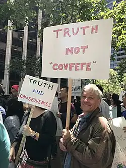 Protester holding a "Truth not 'Covfefe'" sign.