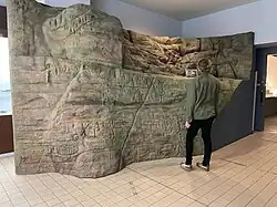 Visitor viewing a reconstruction of one of the walls of Fugoppe Cave, at the onsite museum