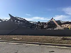 A collapsed metal building, with a foundation and metal beams visible