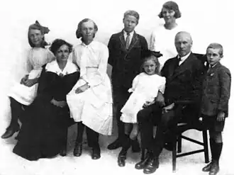 Family photo with six children and two seated adults