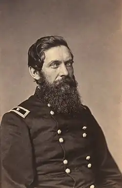 Black-and-white photograph of a bearded Caucasian man wearing a dark-colored military uniform facing the camera