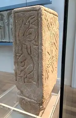 A narrow side of the stone, depicting a serpent.