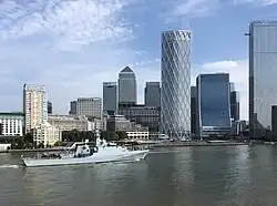 HMS Tamar sailing past Canary Wharf