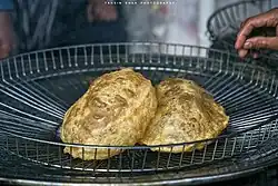 Thin bread is fried in oil and eaten with a salty curry of chickpeas, potatoes and sweet pudding.