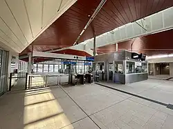 Interior of the station with ticket barriers and customer service office with lifts behind