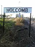The railroad sign for Holcomb. As viewed looking North