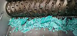 Plastic shredder in operation, processing plastic waste into smaller fragments for recycling.
