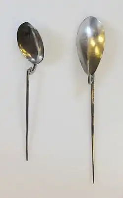 two longhandled spoons, the "handle" is a tapering metal spike