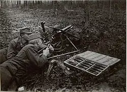 M15 with a gun shield and its trail folded backward in a forest.