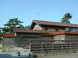 A large house beyond a wall.