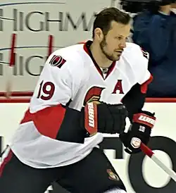 bearded man in hockey equipment
