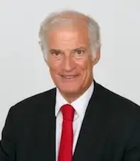 smiling, gray-haired man wearing suit and tie
