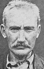 Front-facing black and white mugshot of Higgins