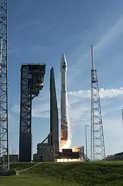 An Atlas V launching from the pad, with the crew access tower (left) complete.