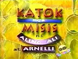 An image with a yellow background. The show title is displayed on the center of the image. The texts "ni Aling Ali at Arnelli" are written below the show title.