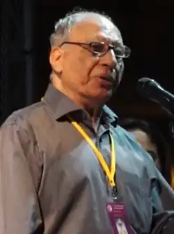 Half-length portrait of Daruwalla speaking into a microphone