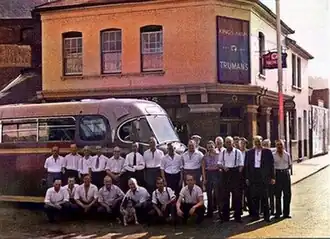 Historic photo of King's Arms pub in Chatham with bus and locals.