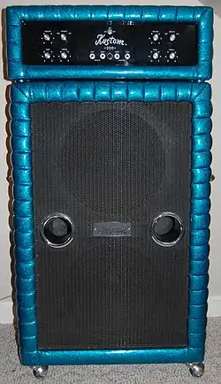A 1970s era amplifier unit sitting on top of a large bass speaker cabinet. The speaker cabinet contains two fifteen-inch loudspeakers.