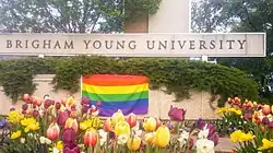 An LGBTQ flag displayed at the main BYU campus sign