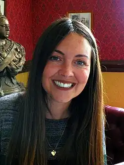 Woman with light brown hair smiling.