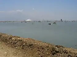 Lake created by mud, with steaming mudflow in background