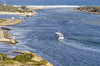 A boat sailing through the entrance to Grippsland Lakes