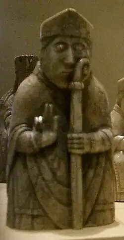 Photograph of an ivory gaming piece depicting a seated bishop