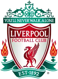 The words "Liverpool Football Club" are in the centre of a pennant, with flames either side. The words "You'll Never Walk Alone" adorn the top of the emblem in a green design, "EST 1892" is at the bottom