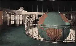 The lobby of the Daily News Building, circa 1941. The lobby of the building includes a circular rotunda with a black glass-domed ceiling. Under this ceiling in a stepped pit with a rotating globe.