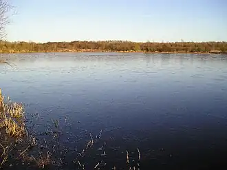 A frozen lake surrounded by trees