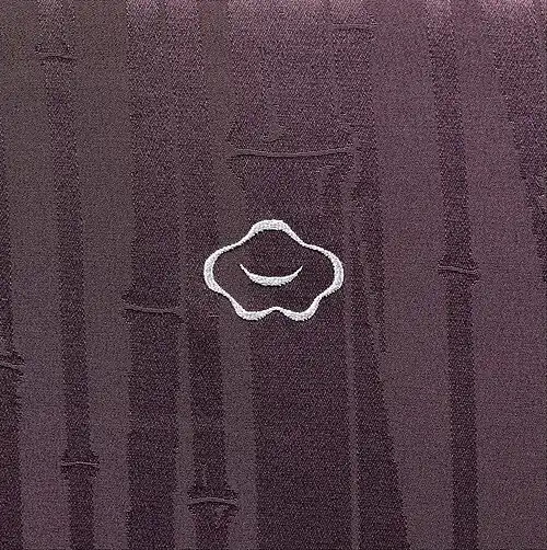 A figured silk (rinzu) kimono woven with a bamboo pattern, and embroidered with a white mon