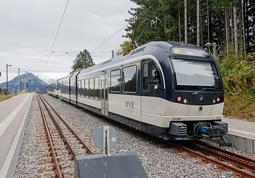 Blue and white train next to platforms