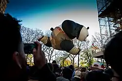 A massive parade balloon of Po from the Kung Fu Panda series looms over a crowd at the Macy's Thanksgiving Day Parade of 2011.