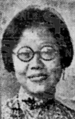 A young smiling Asian woman, wearing round glasses. Her dark hair is cut to jaw length.