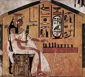 Painting in tomb of Egyptian queen Nefertari playing a board game (commonly identified as senet) on a game board with game pieces, c. 1295–1255 BCE