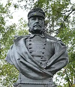 Photo shows a bronze bust of a man in a naval uniform with a cap.