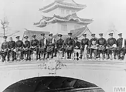 B&W photo of men sitting on a bridge