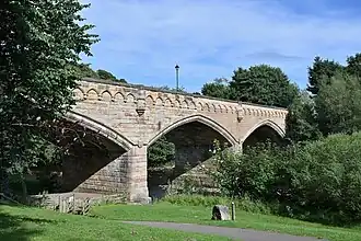 A stone bridge surrounded by greenery