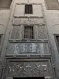 The decoration on the exterior wall above the mosque's rear entrance doors